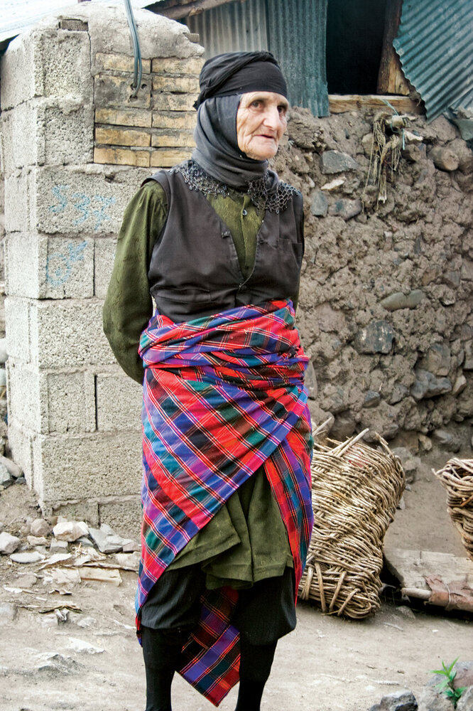 این زن یکی از اهالی شهر ییلاق اشکور رحیم آباد است که پیرزنان معمولاً در آنجا چنین لباس می پوشند.  البته در شب های سرد تابستان همه باید سر و کمر خود را اینگونه محکم ببندند.